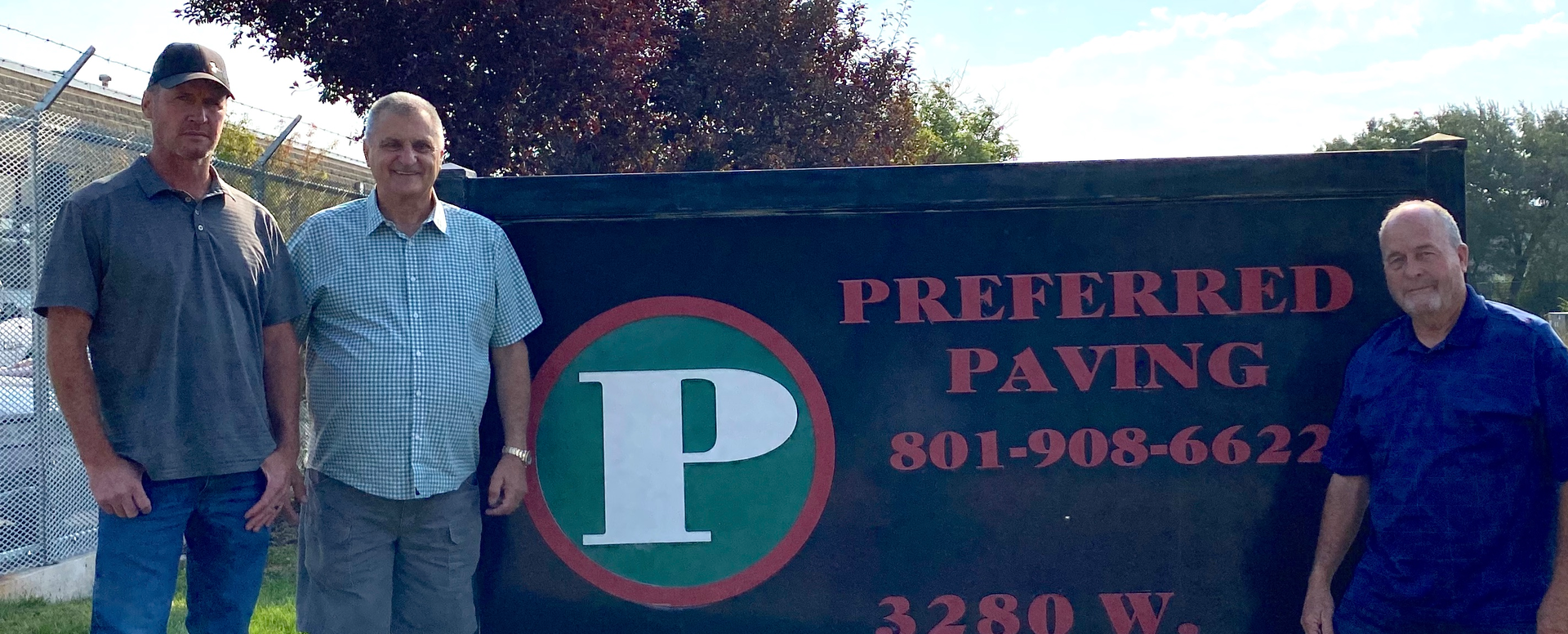 Ryan, Bill, and Curtis standing in front of Preferred Paving's sign